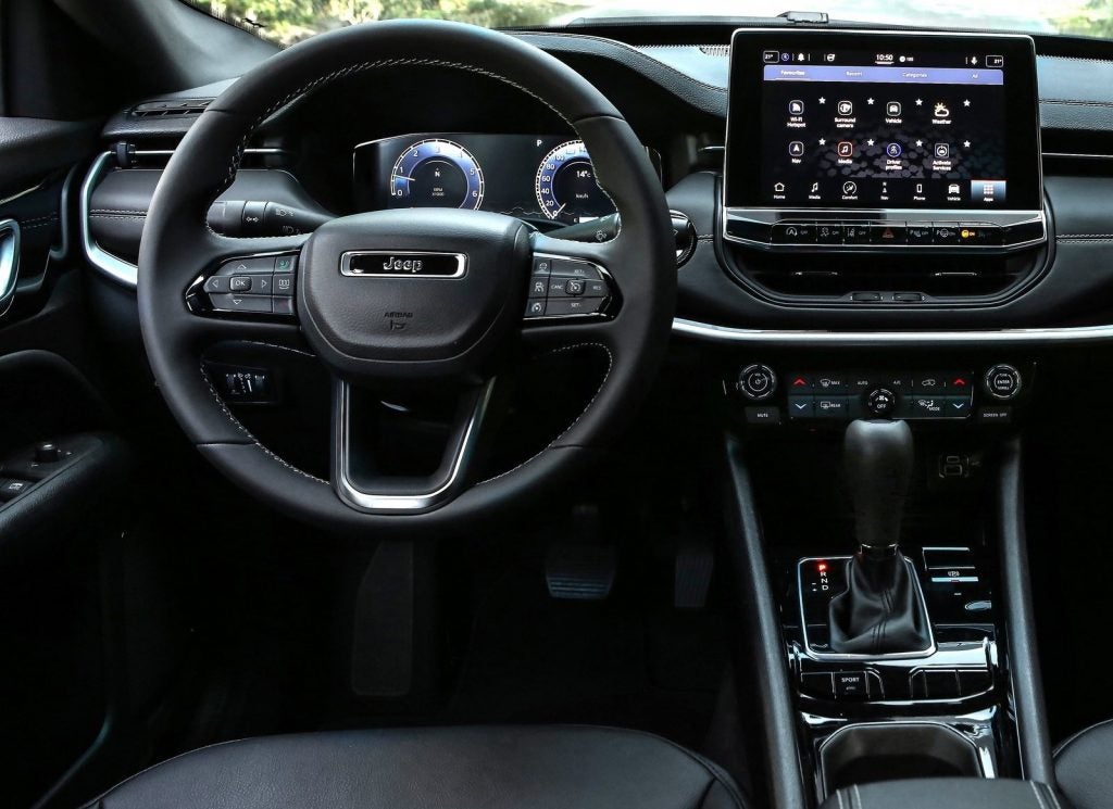 Driver seat view of dashboard and steering wheel inside the new 2022 Jeep Compass for sale in Stuart, FL.