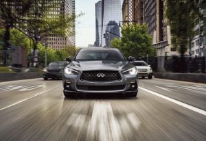 Front view of Grey 2024 INFINITI Q50 driving through a city | Greenwich, CT