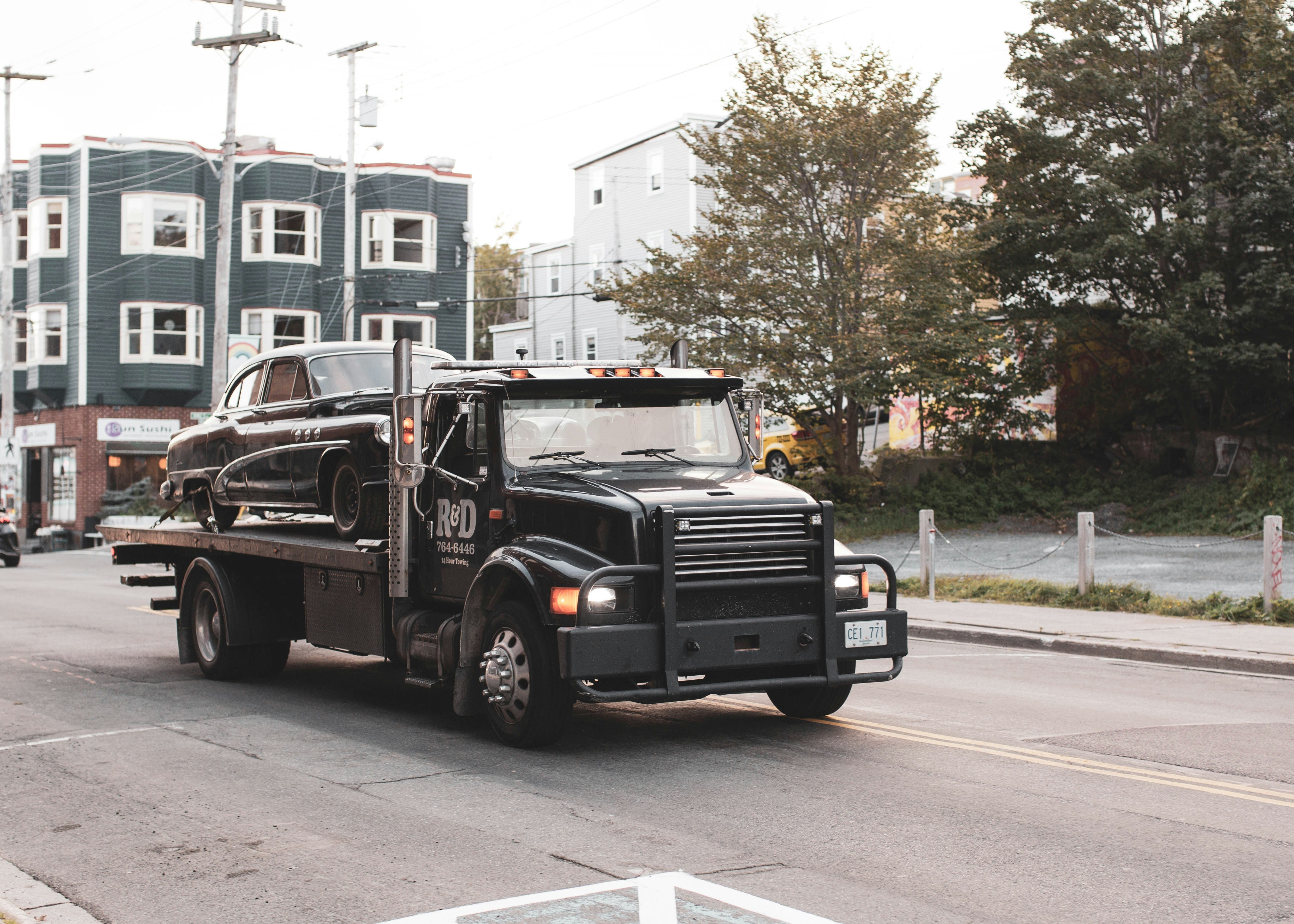 Tow truck towing a car down a road