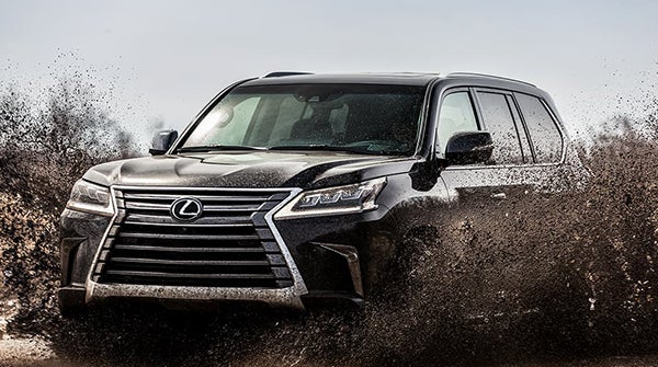 Black Lexus SUV driving through mud in El Monte, CA