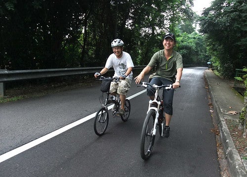 Two friends bike riding up a road