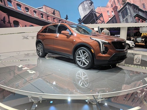 Orange Cadillac XT4 on a glass stage