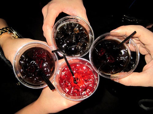 people cheering their drinks together at a bar