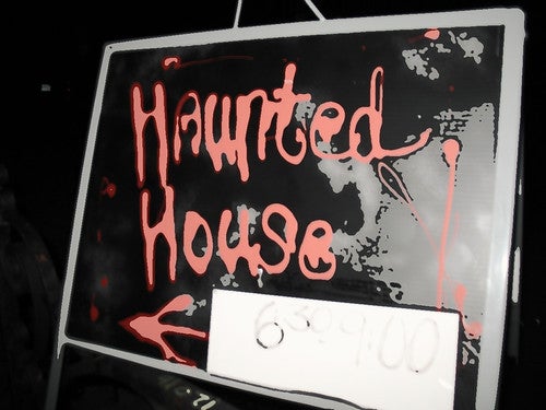 A black sign with "Haunted House" written in redgont