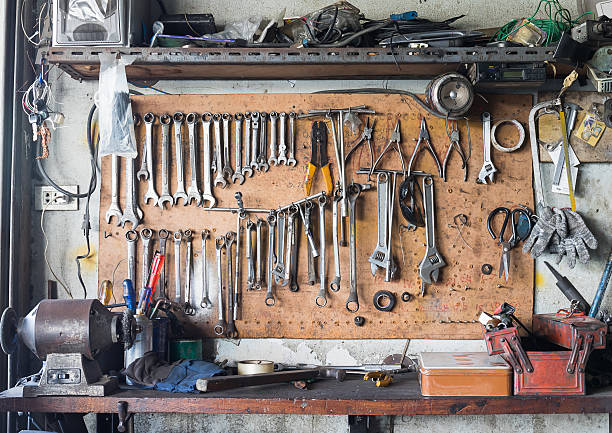 Old tools hanging on wall in workshop , Tool shelf against a wall