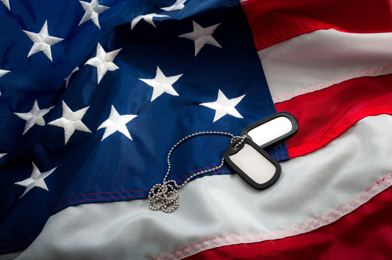 Military Dog Tags Laying Across The American Flag