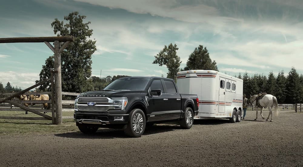 A black 2025 Ford F-150 towing a trailer.