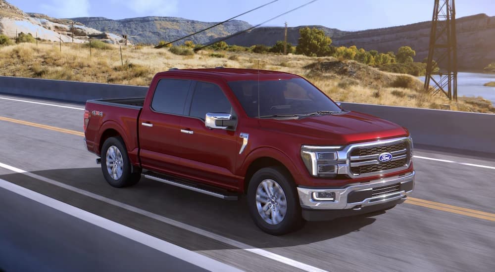 A red 2026 Ford F-150 driving on a bridge