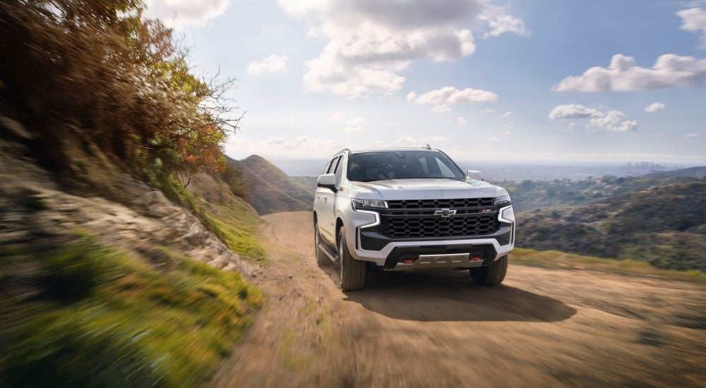 A white used 2021 Chevy Tahoe Z71 off-roading on a dirt trail