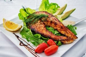 Grilled salmon on a bed of salad plated on a square white plate. | St. Louis, MO