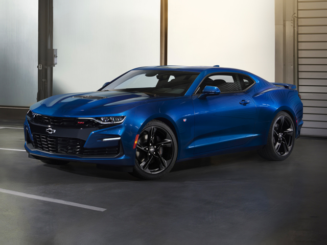 An all-new Riptide Blue Metallic Chevy Camaro parked in a parking garage in front of a roll down exit car door in Sterling, VA.