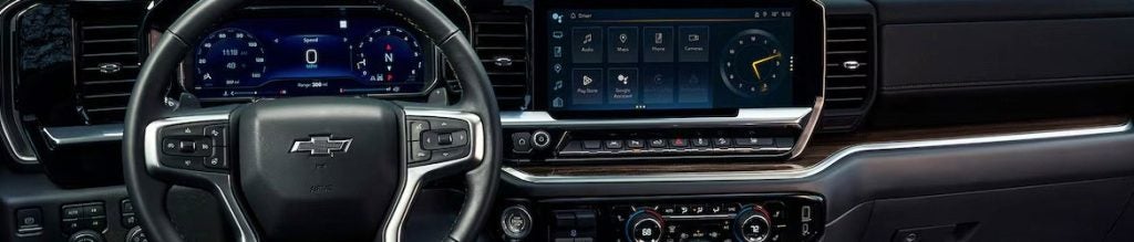 Black and silver steering wheel and dash of an all-new 2025 Chevy Silverado 1500. - Ted Britt Chevrolet