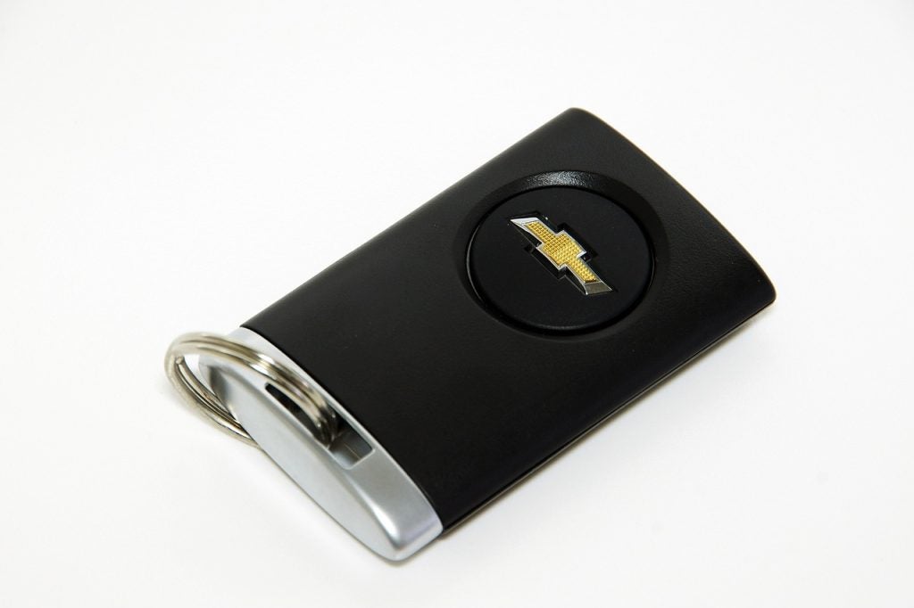 Chevy smart key fob sitting alone on top of a white desk at Ted Britt Chevy.