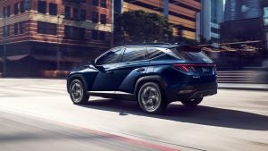Profile view of a blue 2022 Hyundai Tucson being driven on the road. | Hyundai dealer in Little Rock, AR.