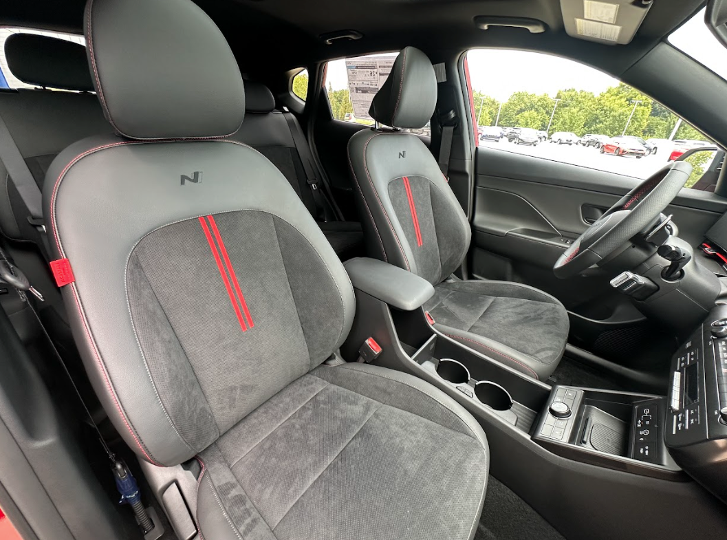 Front interior of a sporty Hyundai SUV with black and red trim