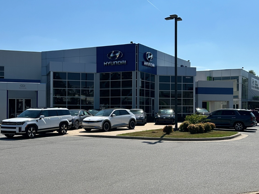 Exterior of Crain Hyundai of Little Rock dealership with new Hyundai vehicles on display under clear blue skies