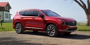 Profile view of a parked red 2021 Hyundai Santa Fe. | Hyundai dealer in Little Rock, AR.