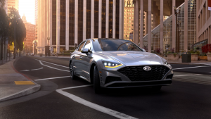 A silver 2022 Hyundai Sonata on the road with buildings in the background. | Hyundai dealer in Little Rock, AR.