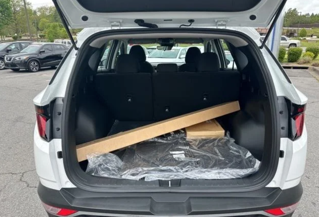 Open trunk of a Hyundai SUV with boxed accessories inside