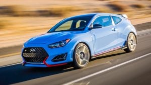 Profile view of a light blue 2022 Hyundai Veloster being driven on the road. | Hyundai dealer in Little Rock, AR.