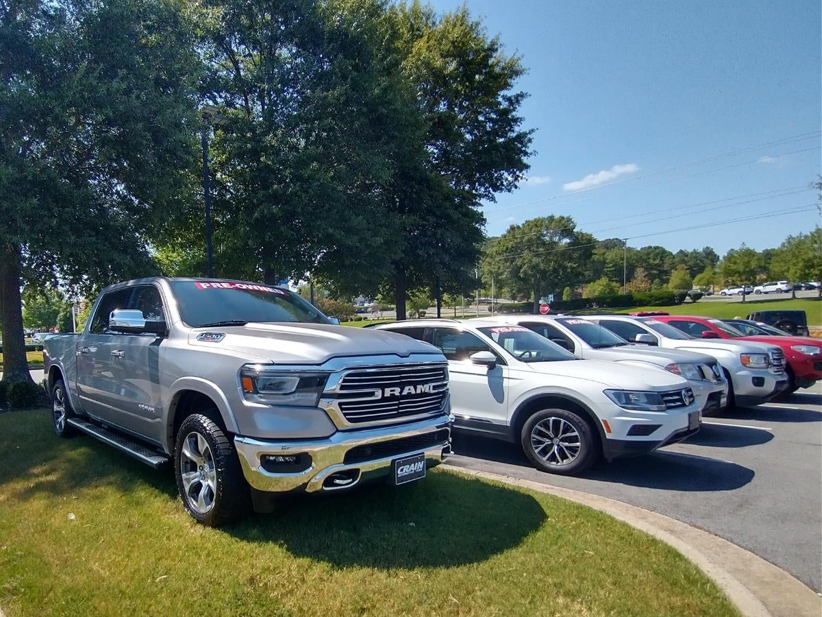 A silver Ram truck and several pre-owned SUVs parked at Crain Hyundai of Little Rock, showing the wide range of vehicles customers can sell or trade through the Crain Buys Cars program.