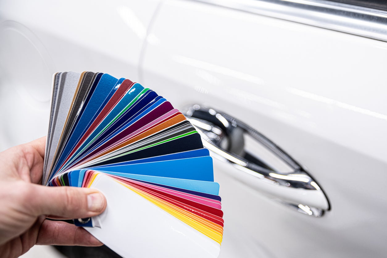 Man choosing color of his car with color sampler.