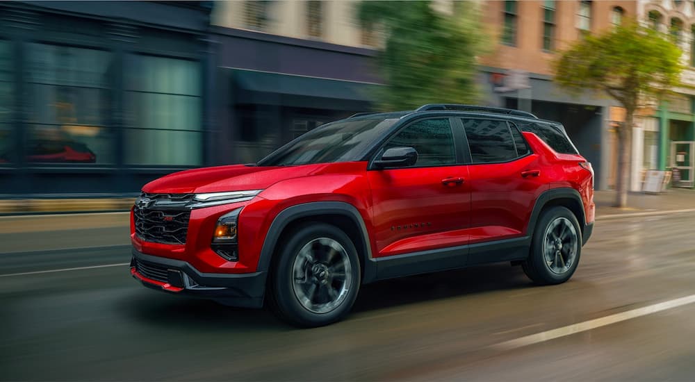 Red 2026 Chevy Equinox RS for sale in Bloomington driving down a city street.