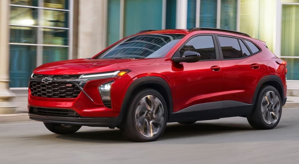 Red 2026 Chevy Trax 2RS driving down a city street.