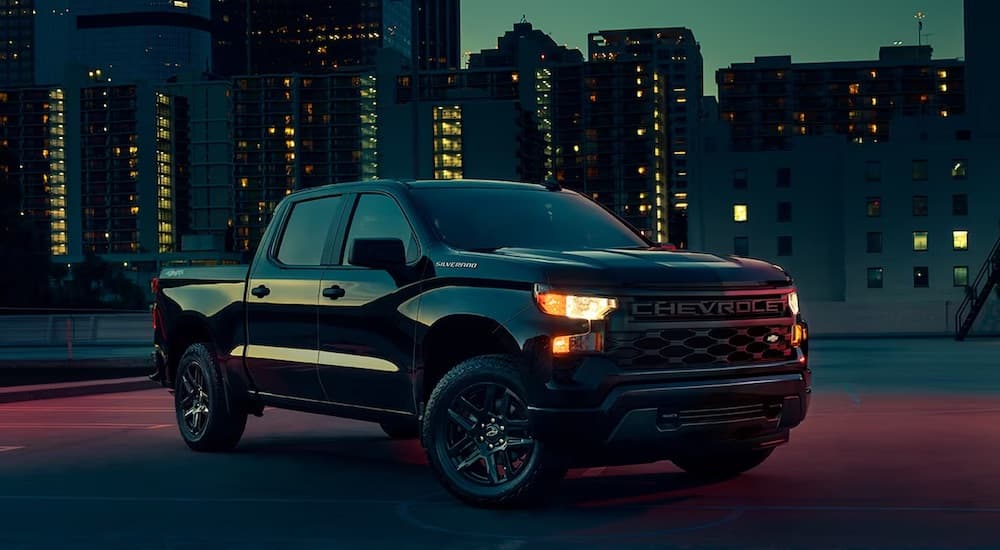 A black 2025 Chevy Silverado 1500 Custom is shown from the front at an angle.