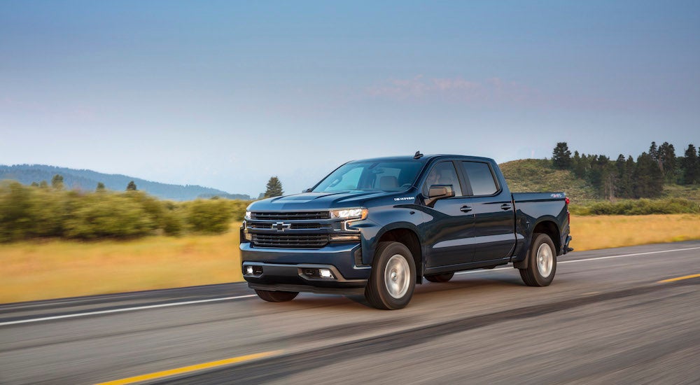 A blue 2025 Chevy Silverado 1500 RST on a rural road.