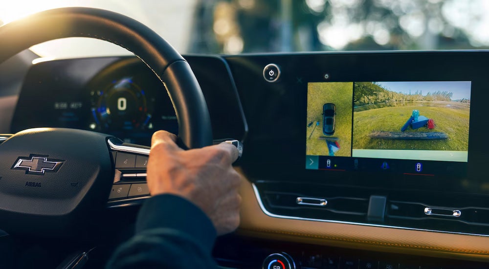 A driver using the 360-degree camera view in a 2025 Chevy Equinox for sale.