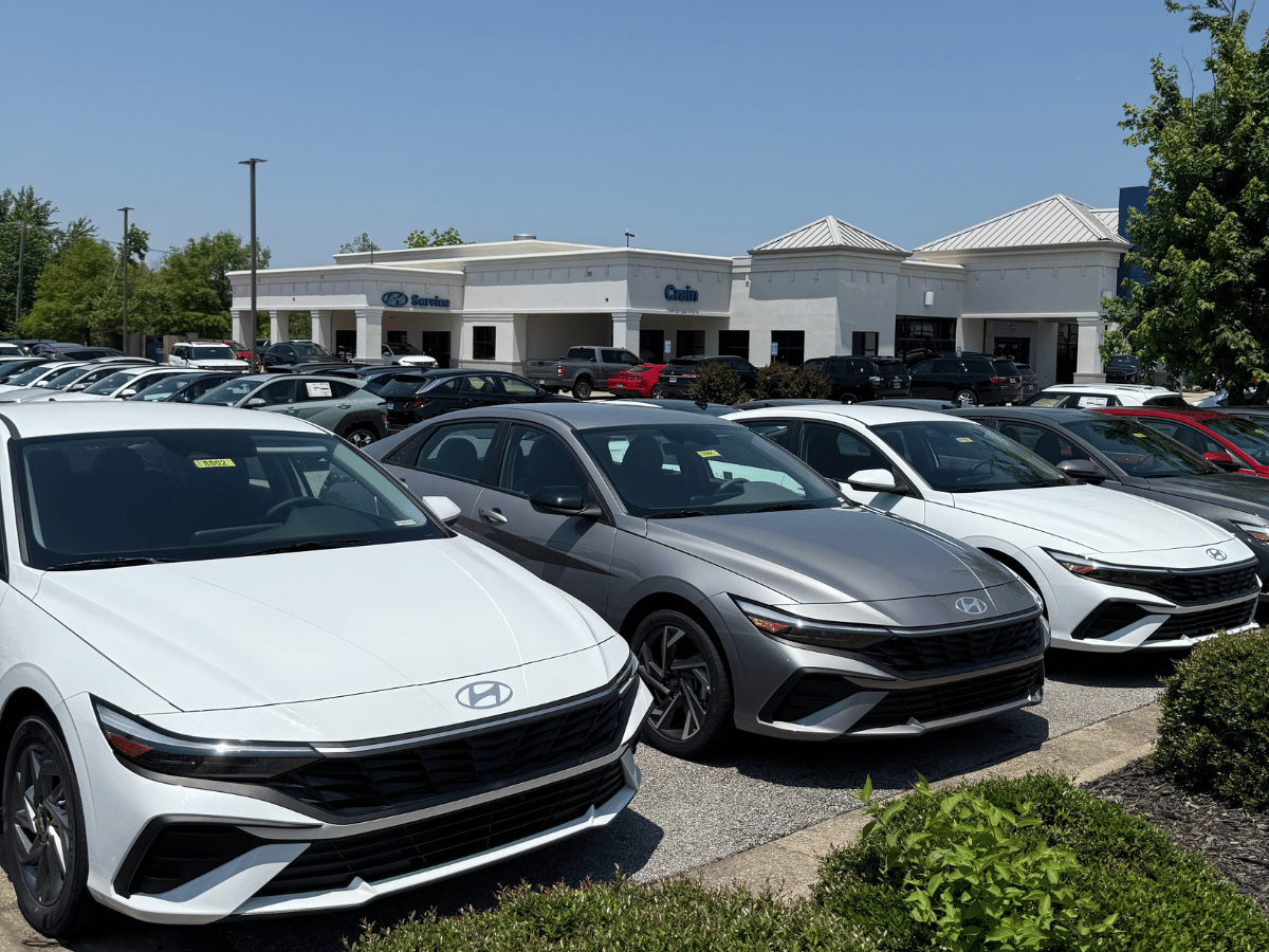 2025 Hyundai Elantra sedans in white and gray lined up outside Crain Hyundai of Bentonville in Northwest Arkansas