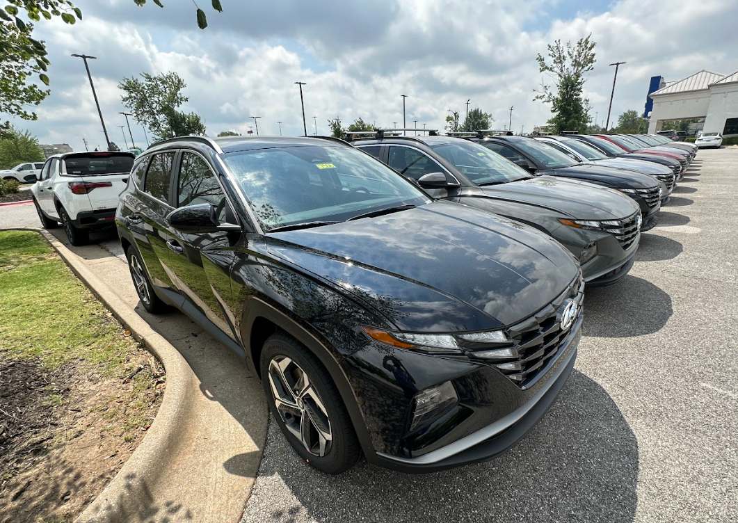 Row of new Hyundai SUVs at Crain Hyundai of Bentonville dealership lot on a sunny day