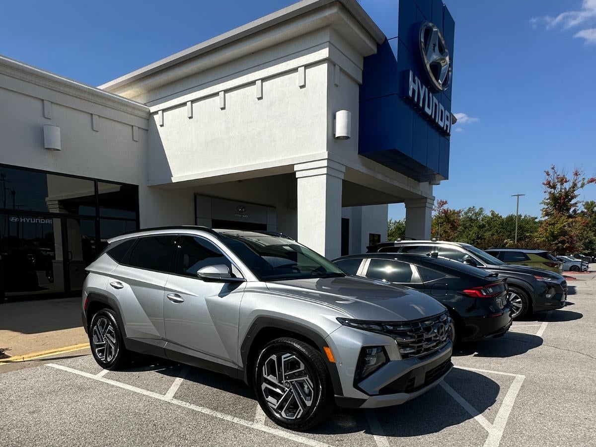 A silver Hyundai Tucson parked outside Crain Hyundai of Bentonville on a sunny day, showcasing new Hyundai models available in Northwest Arkansas.