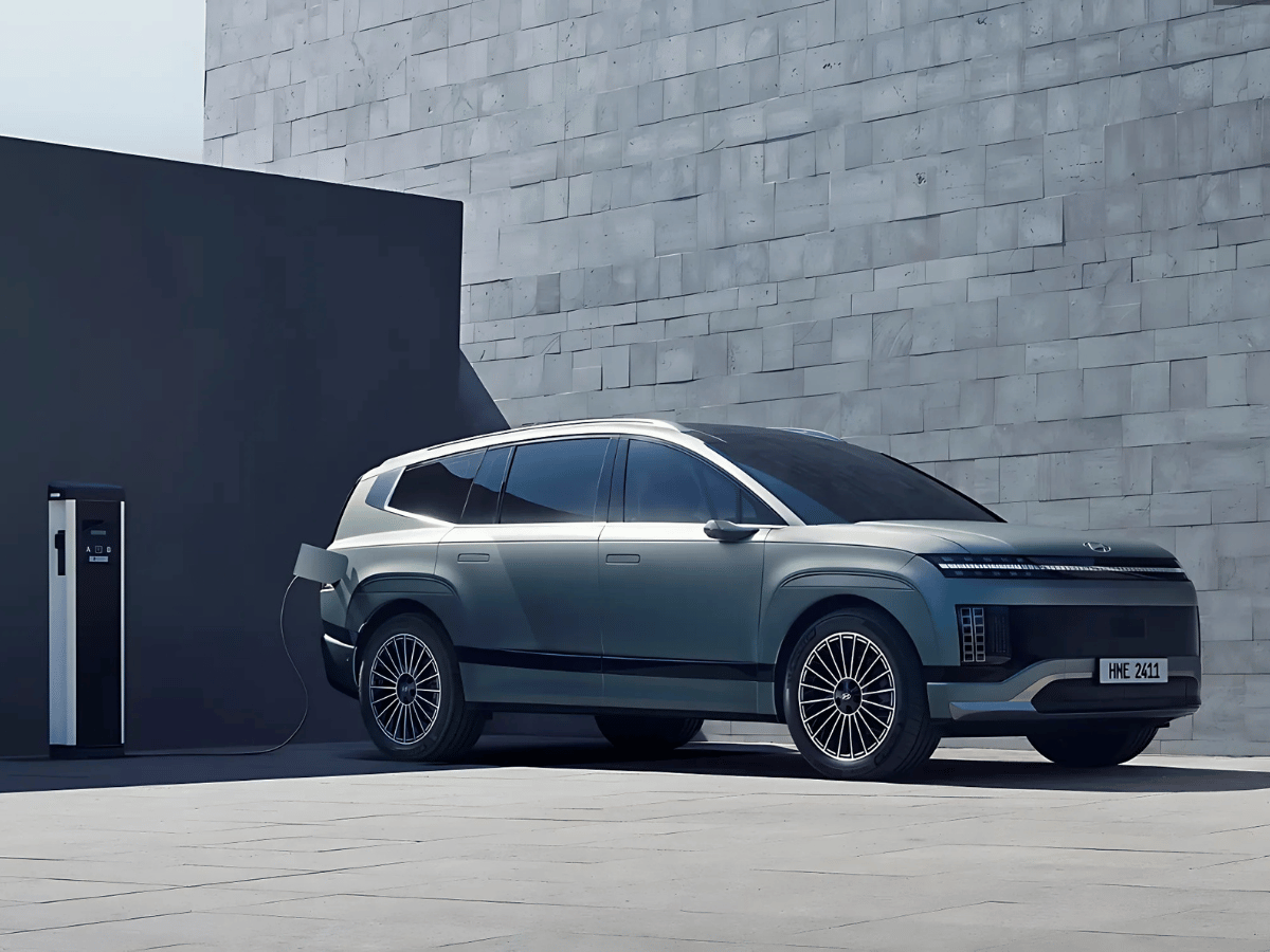 Hyundai Ioniq 9 electric SUV charging at a modern charging station with a sleek gray exterior and futuristic styling