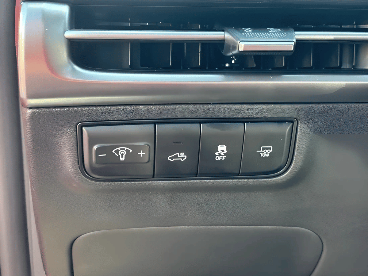 Close-up of interior control panel in the 2025 Hyundai Santa Cruz showing towing, traction control, and headlight adjustment buttons