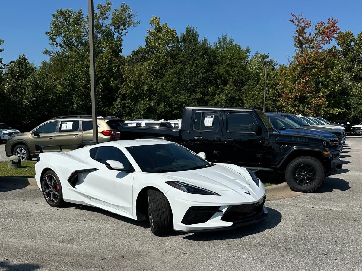 White sports car and black SUV parked at Crain Hyundai of Bentonville, where drivers can sell or trade their vehicles through the Crain Buys Cars program.