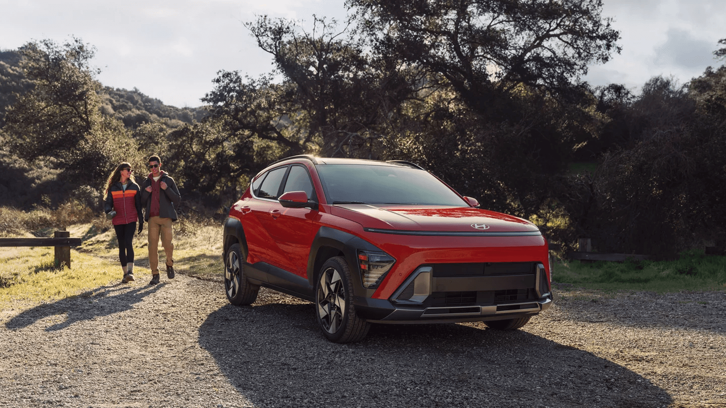 two people with a red Hyundai Kona SUV