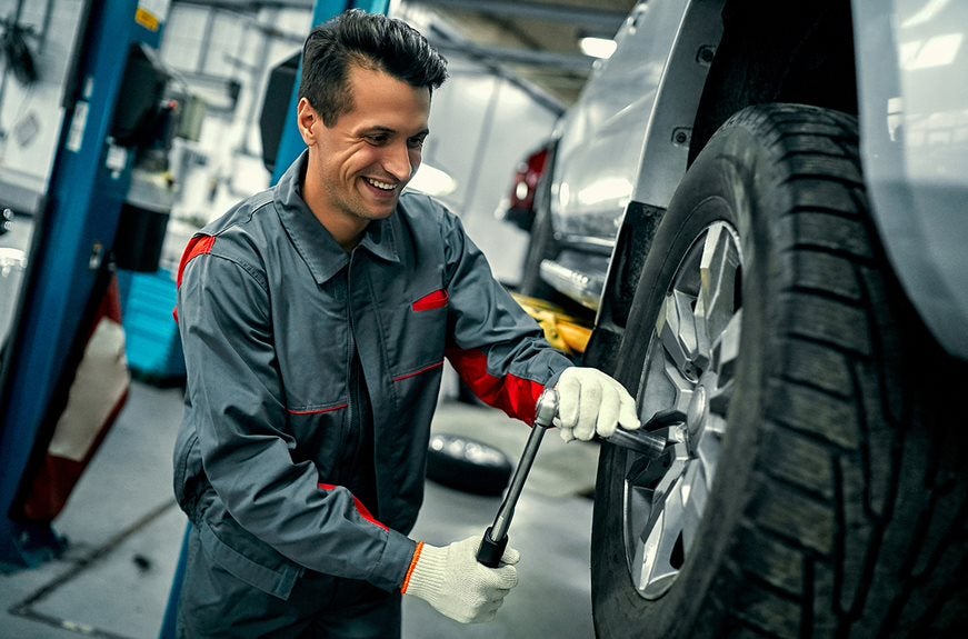 Technician performing tire rotation service