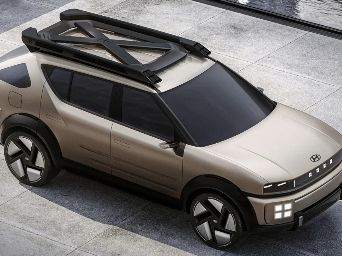 Hyundai Initium hydrogen-powered SUV parked near a water feature with futuristic design and roof rack.