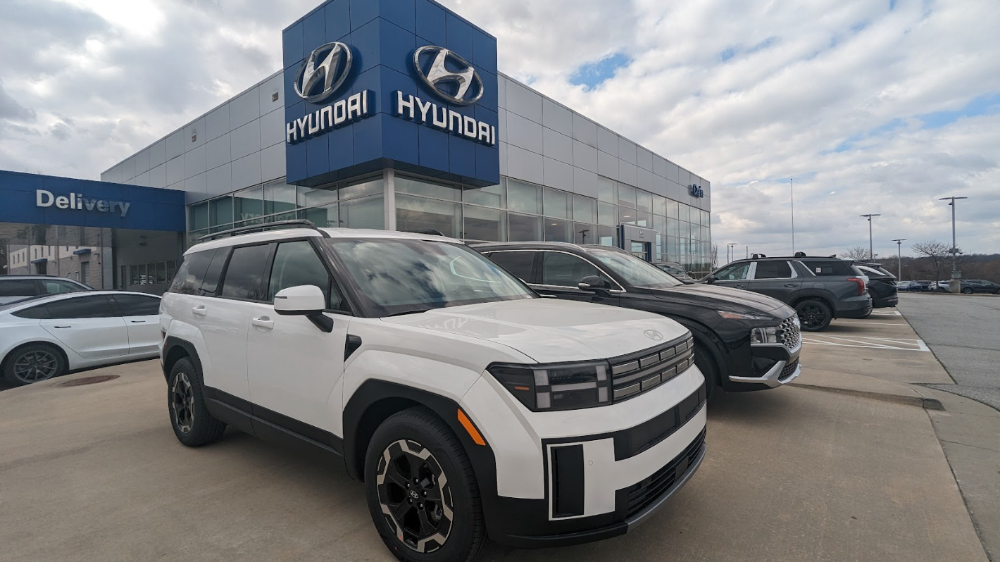 White Hyundai Santa Fe parked outside Crain Hyundai of Fayetteville dealership.