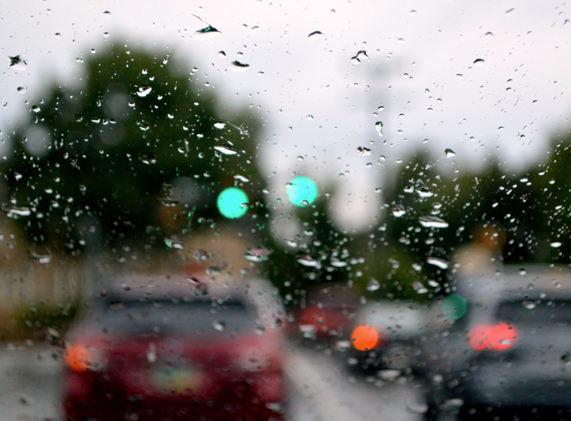 Windshield view through rain-speckled glass on a busy street in Fayetteville, AR