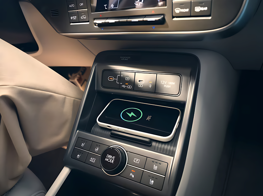 Close-up of a smartphone charging wirelessly in a Hyundai vehicle equipped with Hyundai Digital Key 2 and drive mode selector.
