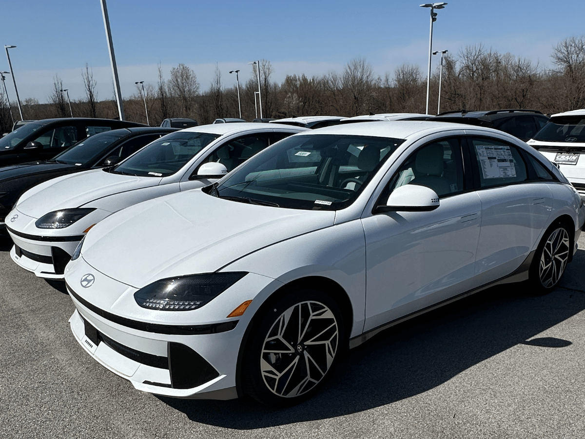 A row of 2025 Hyundai Ioniq 6 electric sedans parked at Crain Hyundai of Fayetteville under a clear sky.