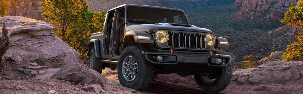 Dark gray Jeep Gladiator Mojave parked on a rocky desert trail.