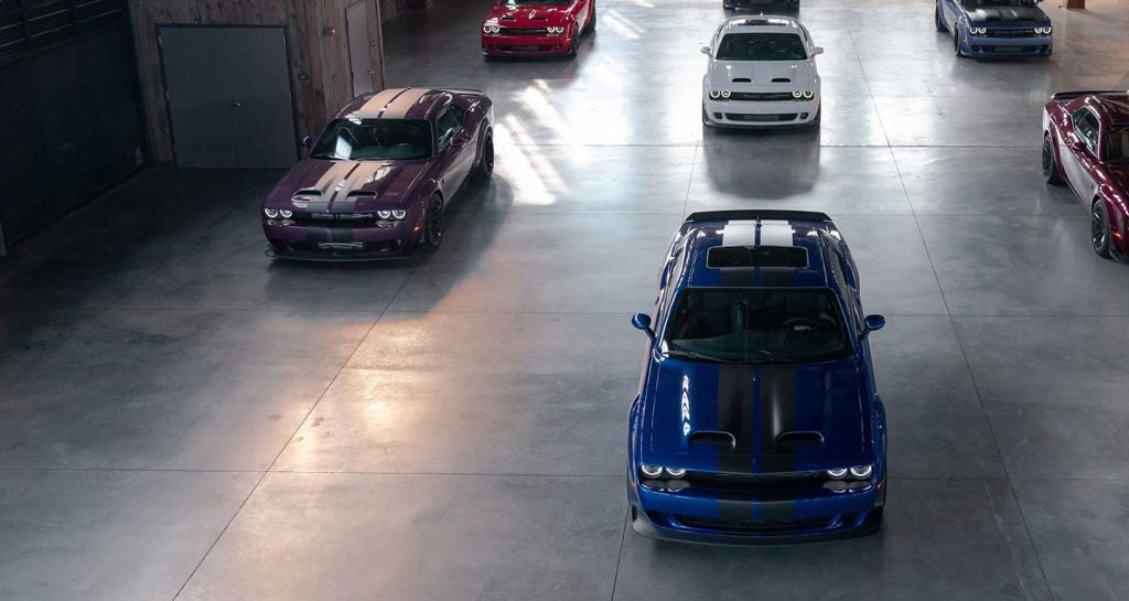 Multiple Dodge Challenger muscle cars parked inside a garage.