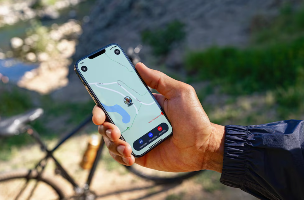 Close-up of a smartphone displaying a live GPS map, showcasing OnStar Guardian app features outdoors