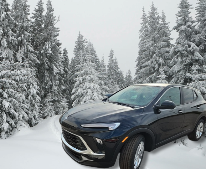 Black Buick Envista SUV parked in a snowy forest landscape