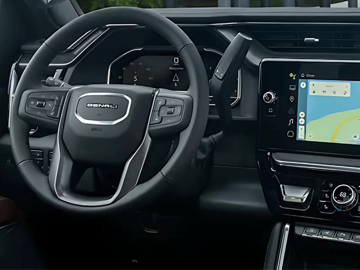Close-up of GMC Denali steering wheel and dashboard display featuring navigation screen and premium controls