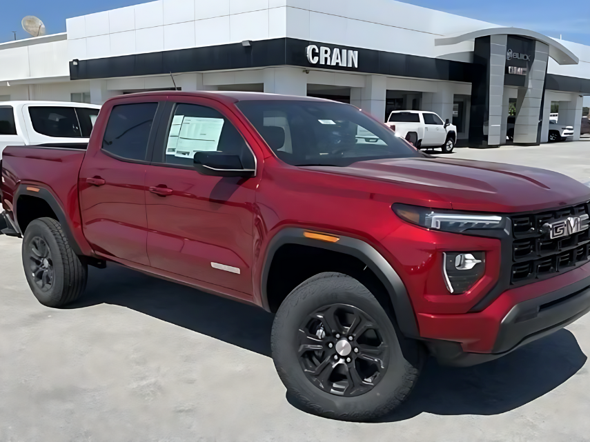 Red GMC Canyon pickup truck parked at Crain Buick GMC in Springdale, Arkansas